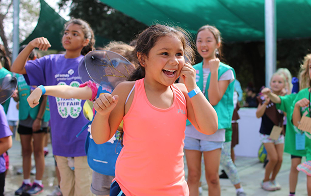 Young Girl Scout having fun at an outdoor family fitness event 