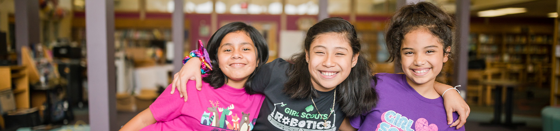  Three Girl Scouts smiling with arms around each other 