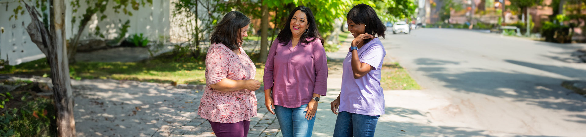  three adult girl scout volunteers standing outside and smiling 